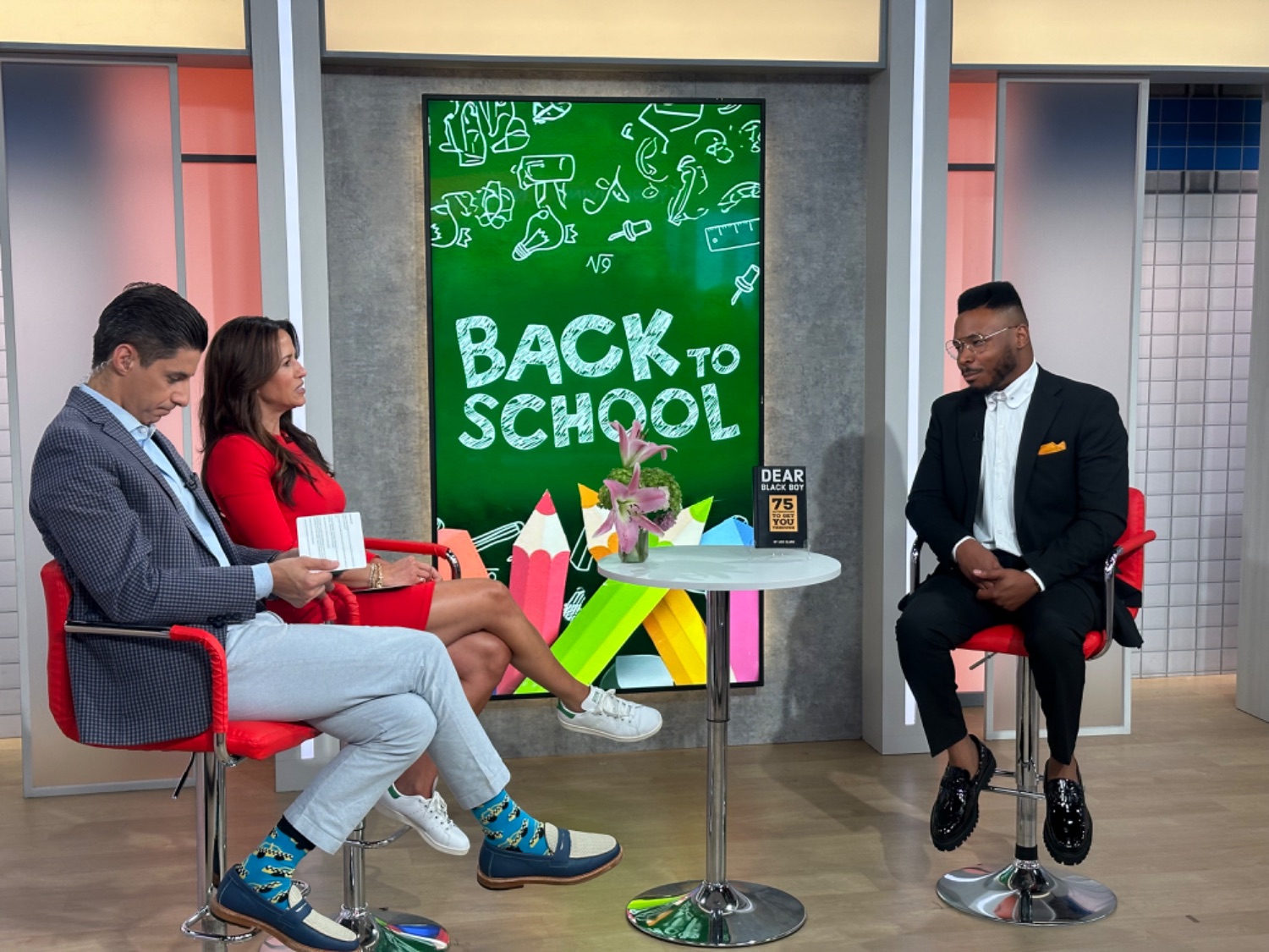 Ace Clark interviewed on a morning news set with Dear Black Boy on display